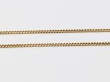 a long gold chain on a white surface