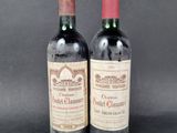 two bottles of red wine sitting next to each other on a table
