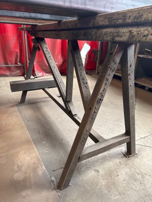 a wooden table with a black top in a room