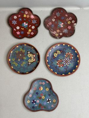 quatre petites assiettes ornées de fleurs et de papillons, accrochées au mur