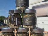 six jars of spices sit on top of a wooden table