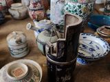 de nombreux vases et assiettes sur la table dans cette pièce