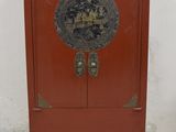 une petite armoire rouge ornée d'un décor doré