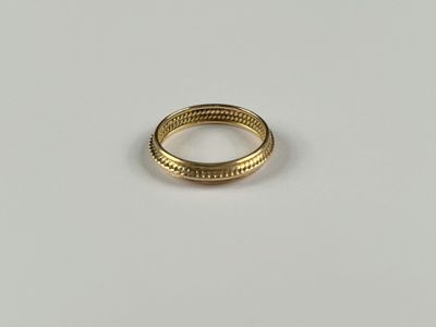 gros plan d'une bague en or sur une surface blanche