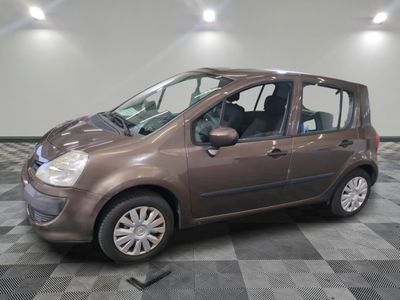 une photo d'une petite voiture marron garée dans un garage