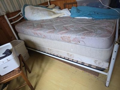 un lit sur lequel se trouvent un matelas et une imprimante
