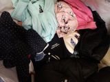 a pile of clothes that is on a bed