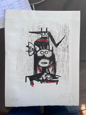 quelqu'un tient un dessin représentant un homme avec un chat sur la tête