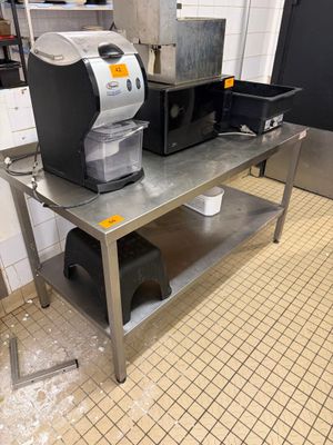 une cafetière posée sur une table en métal dans une cuisine