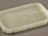a close up of a small white tray on a table