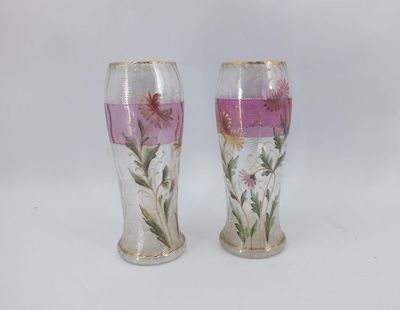 pair of vases with flowers painted on them on a white surface