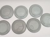 six white plates with silver rims on a white surface