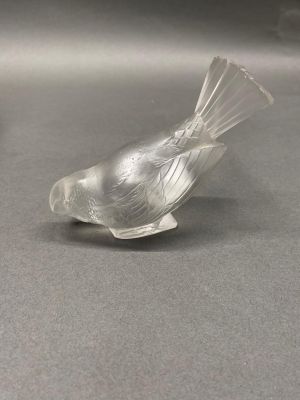 a glass bird that is sitting on top of a table