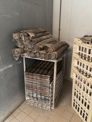 a stack of rolls of toilet paper next to a stack of crates