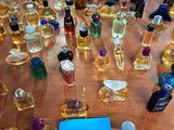many bottles of perfume sitting on a table with a price tag