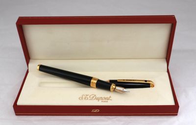 une image représentant un stylo dans une boîte rouge bordée d'or