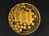 a close up of a gold coin on a black surface