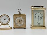 four different types of clocks sitting on a white surface