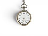 a silver pocket watch hanging from a chain on a white surface