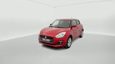 Une voiture rouge est garée dans une pièce blanche aux murs blancs.