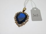 un gros plan d'un pendentif bleu en forme de cœur avec une étiquette de prix
