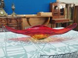 brightly colored glass bowl sitting on top of a table in a room