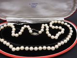 a pearl necklace in a red box on a black surface