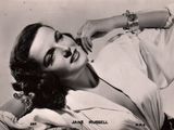 black and white photograph of a woman laying on a couch with her arm resting on her chest