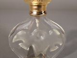 clear glass perfume bottle with a gold top and a gold lid