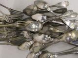 a pile of silver spoons and forks on a table