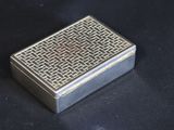an old silver cigarette case sitting on top of a black table