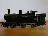 un petit train miniature posé sur une table en bois, avec un mur blanc en arrière-plan