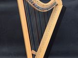 a wooden harp on a stand with a black background