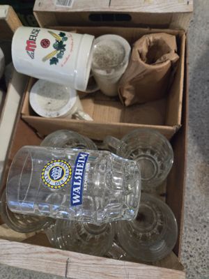 une boîte remplie de bouteilles d'eau vides et de verres vides