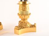 two gold candles that are next to each other