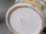 a close up of a vase on a table with a tag on it