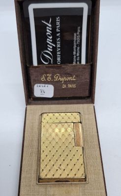 une photo d'un briquet en or dans une boîte avec un porte-cartes