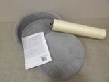 a hat that is sitting on the floor next to a roll of thread