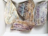 trois morceaux de roche dans une boîte posée sur une table