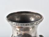 a silver vase that is sitting on a table