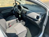 the interior of a small car with the door open and the driver ' s seat down