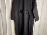 the back of a black coat hanging on a white curtain