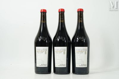 three bottles of red wine sit on a white surface