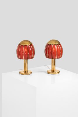 pair of red and gold table lamps on a white surface