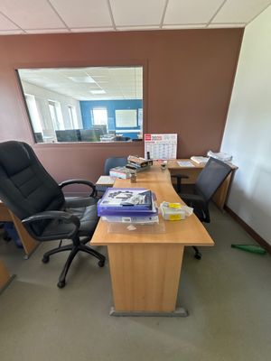 a desk with a chair and a mirror in an office