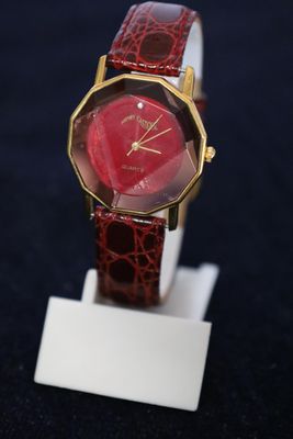 an image of a red watch on a white stand