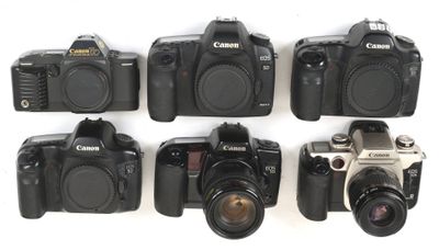 several cameras are lined up in a row on a white surface