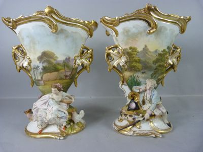 une paire de vases anciens en porcelaine, ornés de figures, posés sur une table