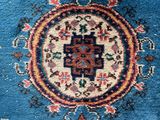 a close up of a blue rug with a medallion design on it