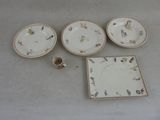 quatre assiettes, une tasse et une soucoupe posées sur une table